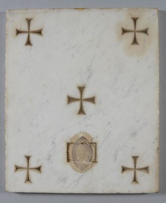 une image représentant une plaque en marbre blanc ornée de croix et d'un médaillon