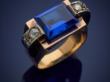 a close up of a ring with a blue stone in it