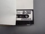 a cassette that is sitting on a table next to a piece of paper