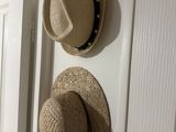 two hats hanging on the wall next to a door