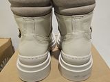 pair of white boots on a cardboard box on a white surface
