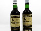 deux bouteilles de vin posées l'une à côté de l'autre sur une surface blanche