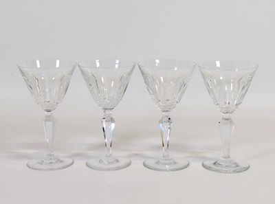 quatre verres à vin transparents posés sur une table blanche