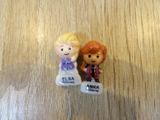 two figurines of a boy and a girl sitting on a table