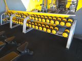 a row of dumb dumbs in a gym with yellow walls