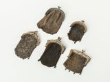 five small purses of different colors and sizes on a white surface