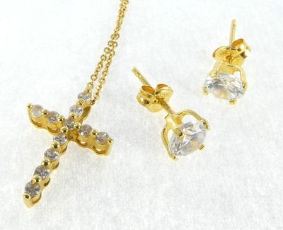 a close up of a necklace and earring with a cross on it