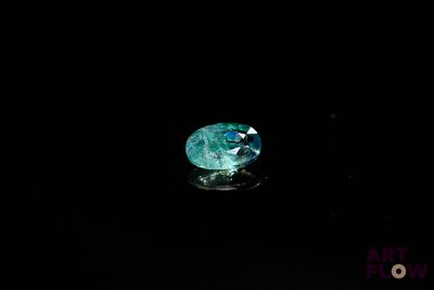 gros plan d'un diamant vert sur une surface noire