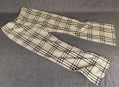 un pantalon à carreaux pour homme posé sur un canapé, sur fond bleu