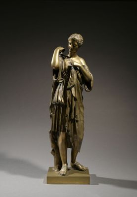 bronze statue of a woman holding a bird on a pedestal