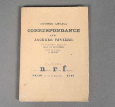 an old book sitting on top of a table on a gray surface