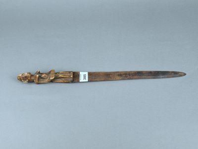 un vieux couteau en bois avec un manche sculpté et un manche en bois