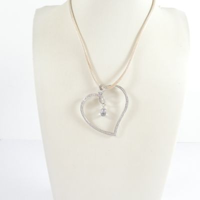 necklace with a heart shaped pendant and a diamond accent on a mannequin neck