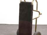 a small hand truck with a luggage bag on the back