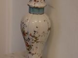 a white vase sitting on a shelf in a room