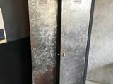 a metal locker with two buckets next to it