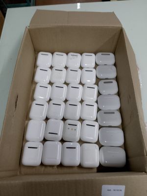 une boîte remplie d'AirPods blancs en forme de pomme posée sur une table