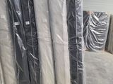 de nombreux rouleaux de matelas emballés dans du plastique dans un entrepôt