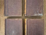 four old books sitting on top of a table next to each other