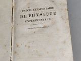 an old book opened to reveal a page of text on a white surface