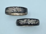 pair of black and gold wedding bands with flowers and leaves