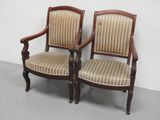 deux chaises en bois avec des assises rembourrées à rayures dans une pièce