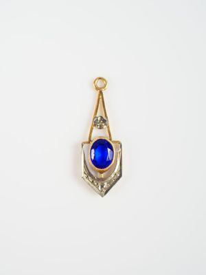 un pendentif en pierre dorée et bleue sur fond blanc