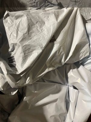 a pile of white sheets on the floor next to a bed