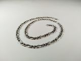 a close up of a silver chain on a white surface