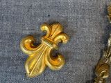 a small gold object on a table next to a silver spoon