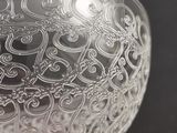 a glass bowl with a design on it on a table