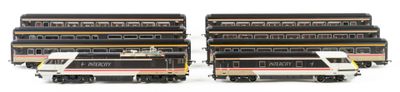 several model trains are lined up in a row on a white surface