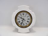 une petite horloge blanche avec des chiffres romains