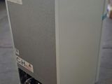a white refrigerator sitting on the floor in a warehouse