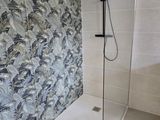 une douche avec une porte en verre dans une salle de bains