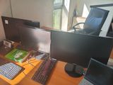 a desk with two monitors, a keyboard and a laptop on it