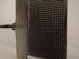 a metal object that is on a white surface