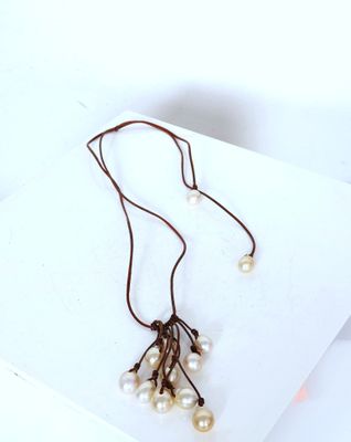 necklace with pearls and leather cord on white background