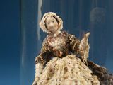 a figurine of a woman in a dress in a glass jar