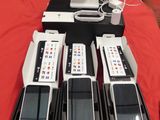 quatre téléphones portables et un ordinateur portable posés sur une table rouge