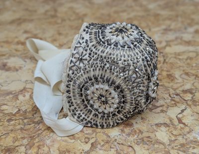 a black and white beaded hat on a table