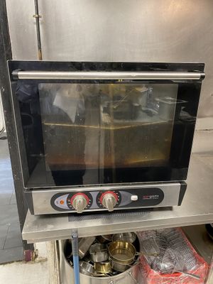 a small oven sitting on a stand in a kitchen