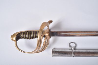 une épée avec une poignée en métal et une paire de ciseaux à côté
