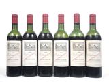 six bouteilles de vin sont alignées sur une surface blanche