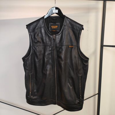 un gilet en cuir noir avec des fermetures éclair, suspendu à un portemanteau dans une pièce