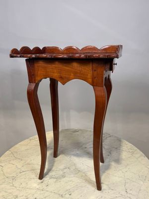 une vieille table en bois avec un plateau en marbre, posée sur un piédestal