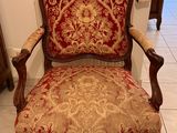 an old chair with a red and gold upholstered seat