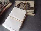 a stack of old photos and a notepad on a table