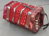 a red accordion sitting on the ground on the ground