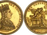 a gold coin with an image of a woman and a bird on it
